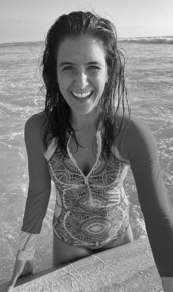 Woman in a patterned swimsuit standing by water